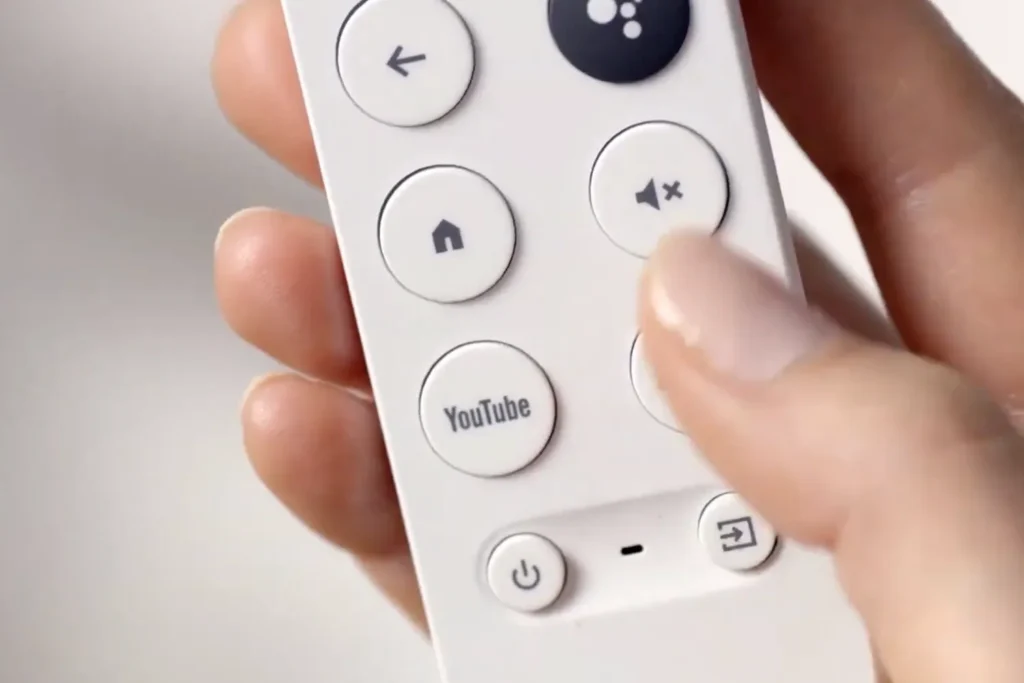 Person pressing buttons on Google TV Voice Remote for manual pairing