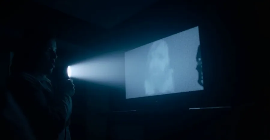 Person shining flashlight on TV screen.
