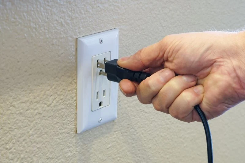 Person unplugging a Samsung TV power cord